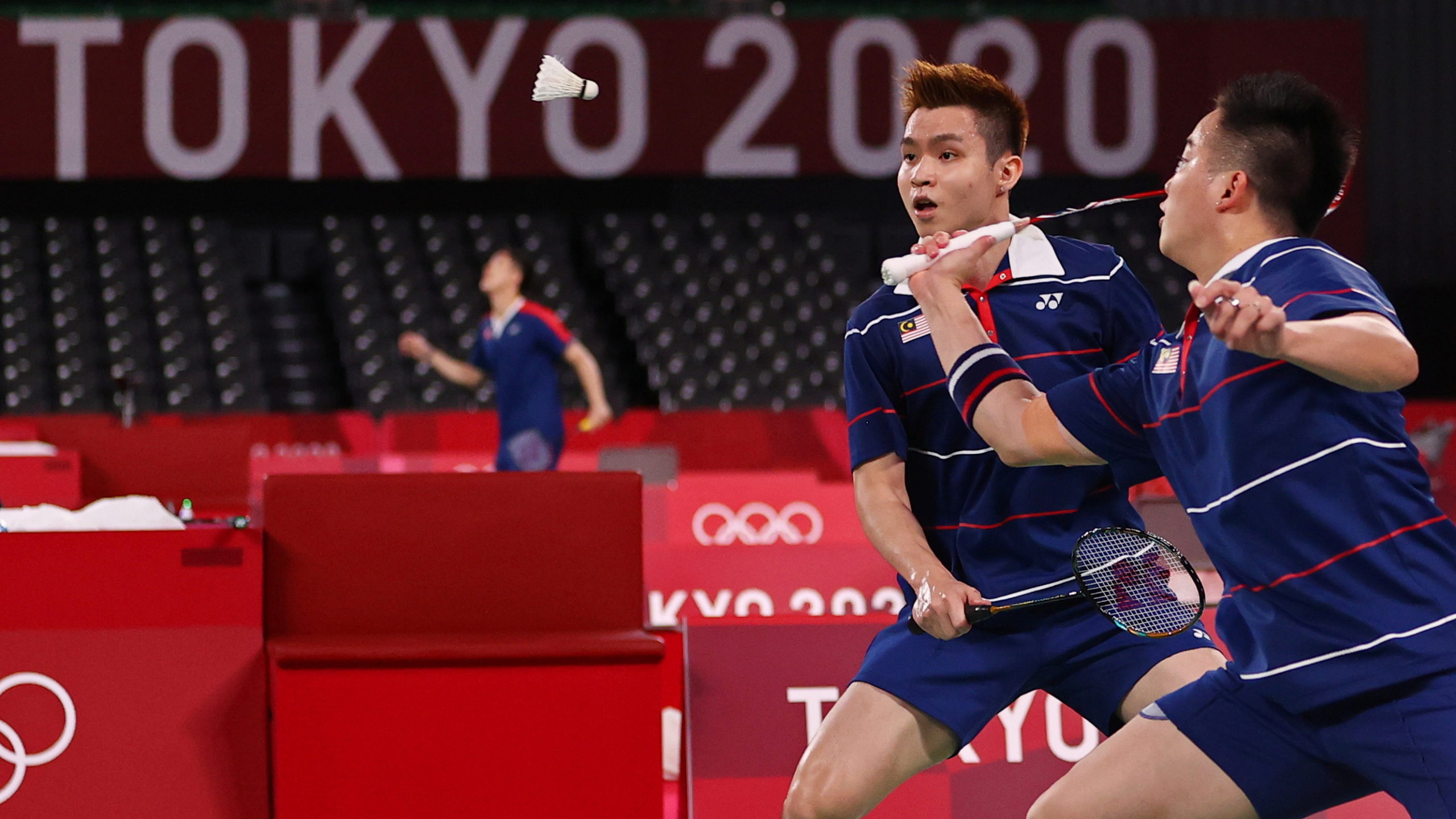 Tokyo 2020 Olympics - Badminton - Men's Doubles - Quarterfinal - MFS - Musashino Forest Sport Plaza, Tokyo, Japan – July 29, 2021. Aaron Chia of Malaysia in action as Soh Wooi Yik of Malaysia looks on during the match against Marcus Fernaldi Gideon of Indonesia and Kevin Sanjaya Sukamuljo of Indonesia. 