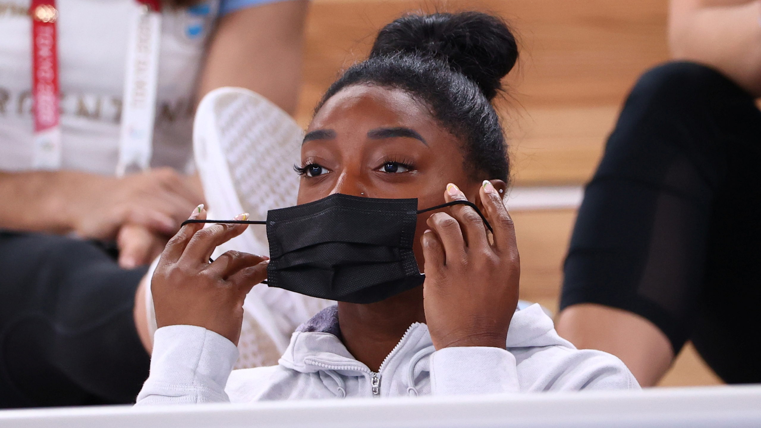 Simone Biles of the United States puts on a protective face mask. 