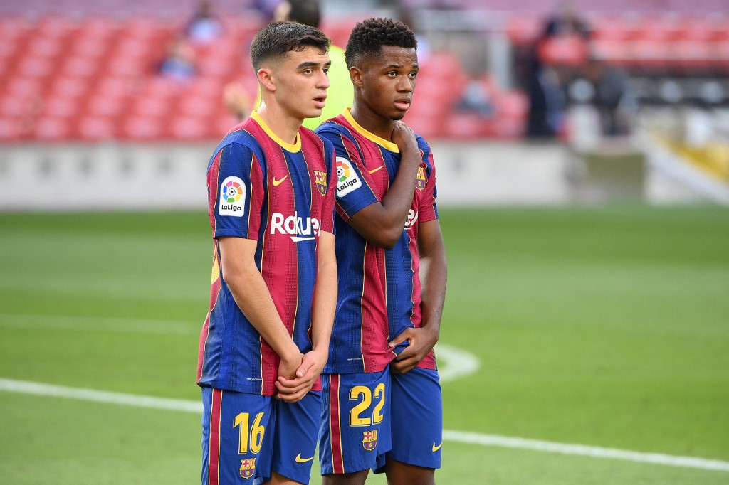 Barcelona's Spanish midfielder Pedri (L) and Barcelona's Spanish midfielder Ansu Fati attend the Spanish League football match between Barcelona and Real Madrid at the Camp Nou stadium in Barcelona on October 24, 2020.