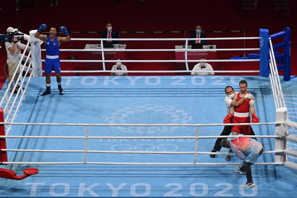 Philippines' Eumir Marcial (blue) celebrates after winning by KO against Armenia's Arman Darchinyan during their men's middle (69-75kg) quarter-final boxing match during the Tokyo 2020 Olympic Games at the Kokugikan Arena in Tokyo on August 1, 2021. 
