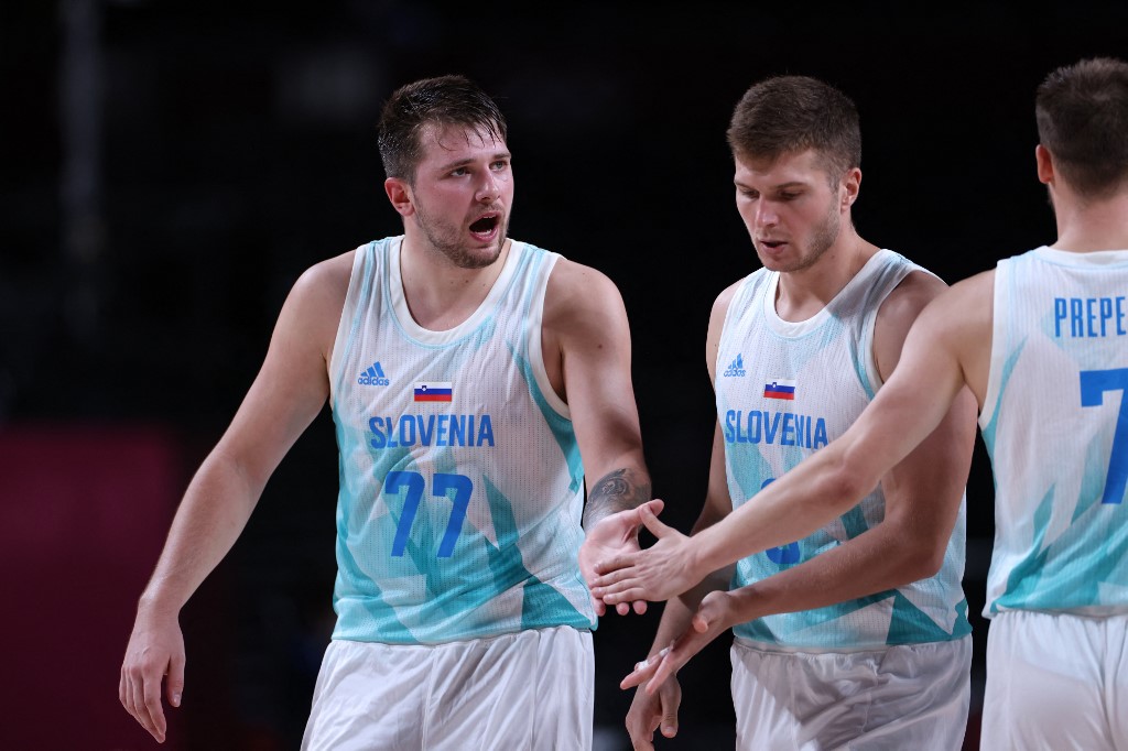  (L) celebrates with teammates after their win in the men's quarter-final basketball match between Slovenia and Germany during the Tokyo 2020 Olympic Games at the Saitama Super Arena in Saitama on August 3, 2021. 