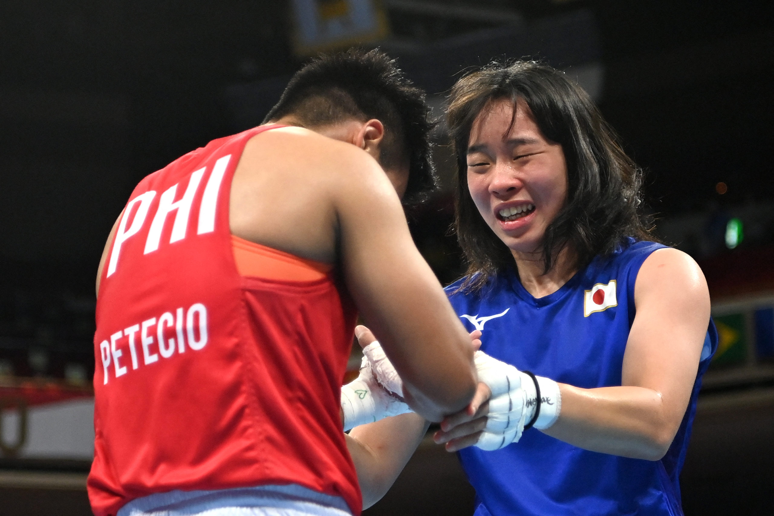 Japan's Sena Irie (blue) celebrates after winning against Philippines' Nesthy Petecio after their women's feather (54-57kg) boxing final bout during the Tokyo 2020 Olympic Games at the Kokugikan Arena in Tokyo on August 3, 2021. 