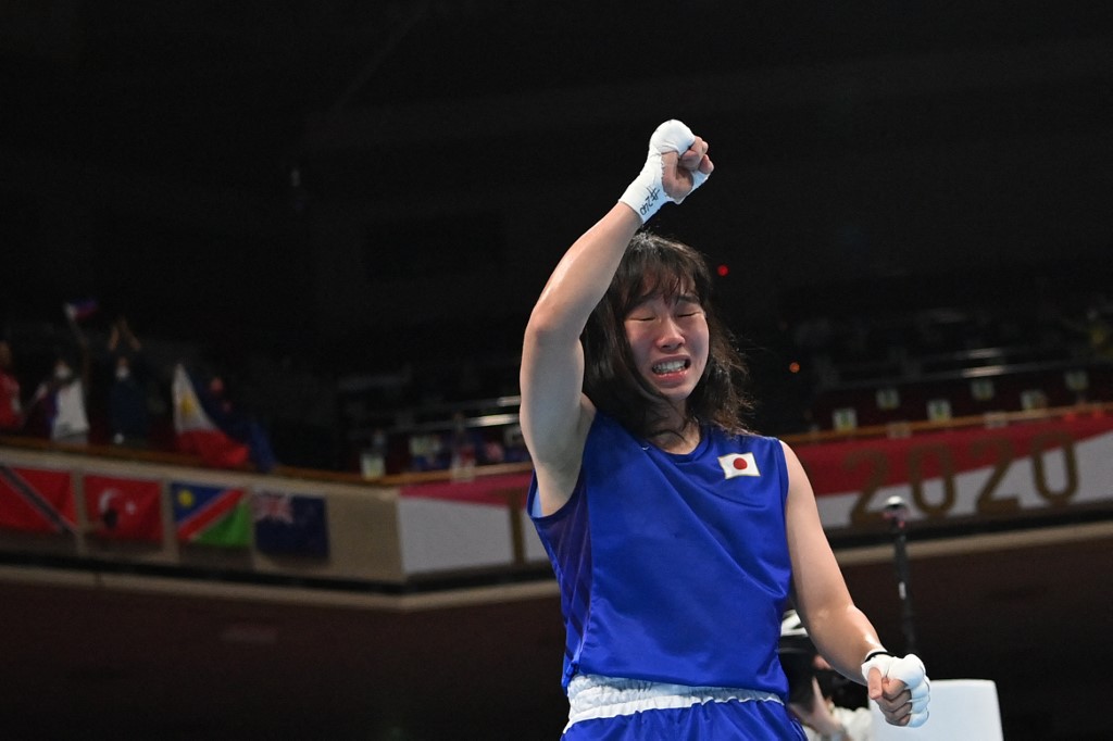 Japan's Sena Irie (blue) celebrates after winning against Philippines' Nesthy Petecio after their women's feather (54-57kg) boxing final bout during the Tokyo 2020 Olympic Games at the Kokugikan Arena in Tokyo on August 3, 2021.