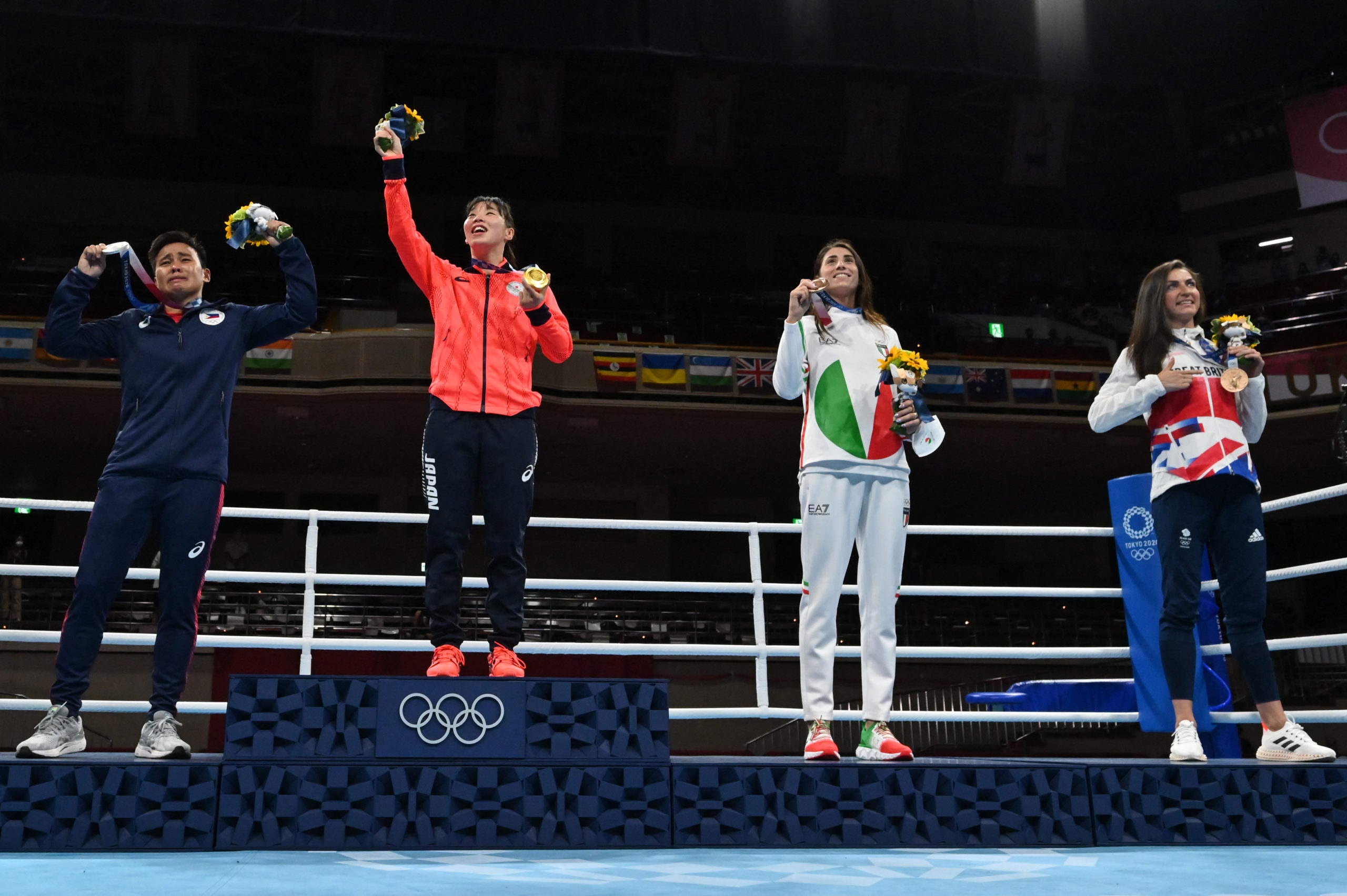 medallist Philippines' Nesthy Petecio, gold medallist Japan's Sena Irie, bronze medallists Italy's Irma Testa and Britain's Karriss Artingstall, pose on the podium after the women's feather (54-57kg) boxing final bout during the Tokyo 2020 Olympic Games at the Kokugikan Arena in Tokyo on August 3, 2021.