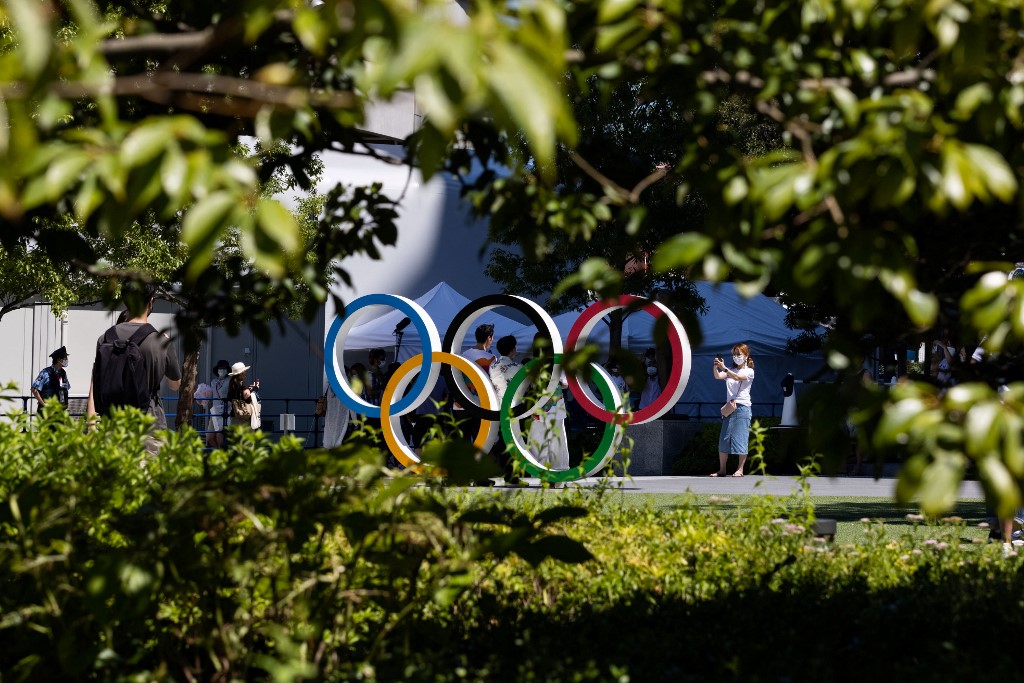 Visitors pose for pictures with the Olympic Rings at the Japan Olympic museum outside the Olympic Stadium, main venue of the Tokyo 2020 Olympic Games, in Tokyo on August 5, 2021. 