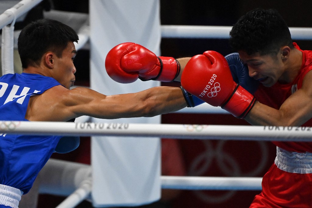 Japan's Ryomei Tanaka (red) and Philippines' Carlo Paalam fight during their men's fly (48-52kg) semi-final boxing match during the Tokyo 2020 Olympic Games at the Kokugikan Arena in Tokyo on August 5, 2021.