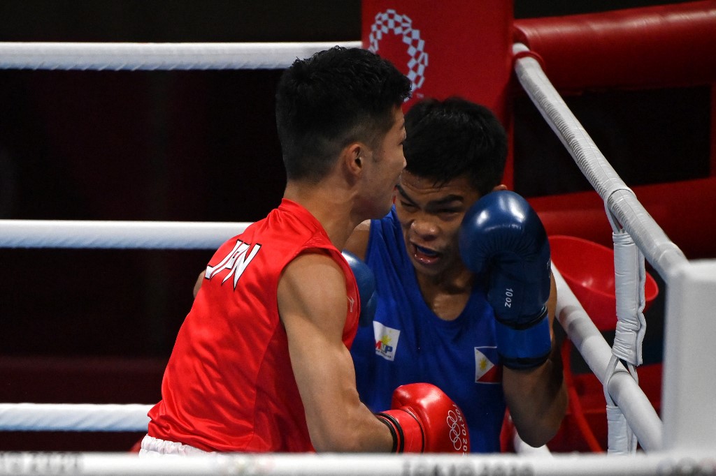 Japan's Ryomei Tanaka (red) and Philippines' Carlo Paalam fight during their men's fly (48-52kg) semi-final boxing match during the Tokyo 2020 Olympic Games at the Kokugikan Arena in Tokyo on August 5, 2021. 