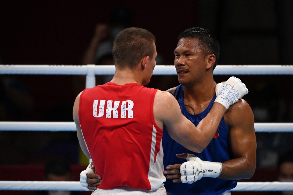 Ukraine's Oleksandr Khyzhniak (red) and Philippines' Eumir Marcial hug after their men's middle (69-75kg) semi-final boxing match during the Tokyo 2020 Olympic Games at the Kokugikan Arena in Tokyo on August 5, 2021