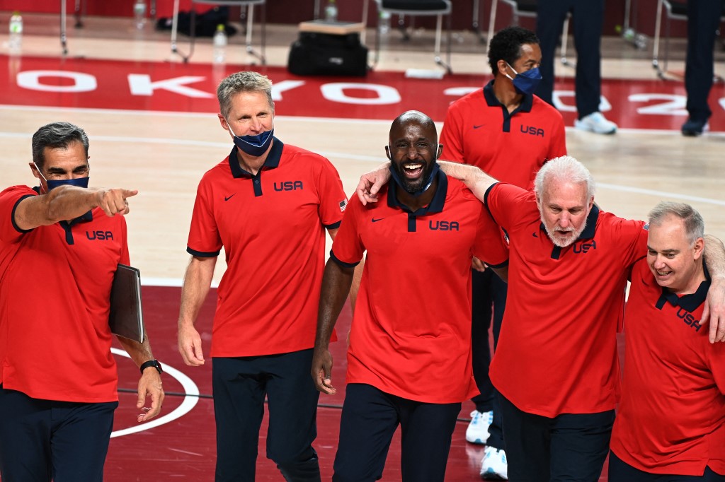 USA's coach GRegg Popovich (2R) celebrates with team members assistants coach Steve Kerr (2L)  and Lloyd Daniel Pierce (3R) after their victory in the men's final basketball match between France and USA during the Tokyo 2020 Olympic Games at the Saitama Super Arena in Saitama on August 7, 2021. (