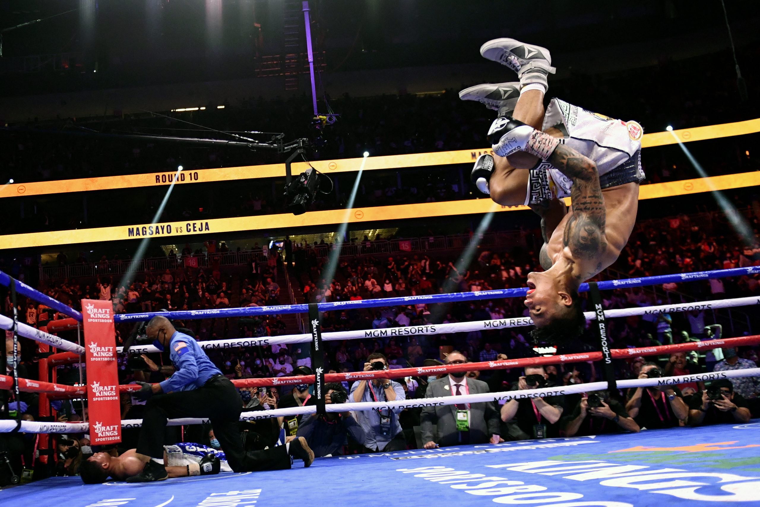 Mark Magsayo (R) of the Philippines backflips as he celebrates after knocking down Julio Ceja (L) of Mexico during the WBA Featherweight Title Eliminator boxing match at T-Mobile Arena in Las Vegas, Nevada on August 21, 2021.