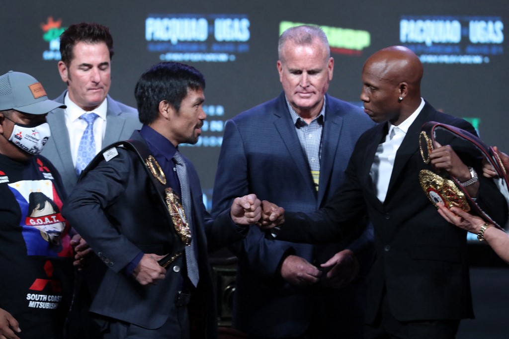 Manny Pacquiao (L) bumps fists with WBA welterweight champion Yordenis Ugas during a news conference at MGM Grand Garden Arena on August 18, 2021 in Las Vegas, Nevada. Pacquiao will challenge Ugas for his title at T-Mobile Arena on August 21 in Las Vegas. 