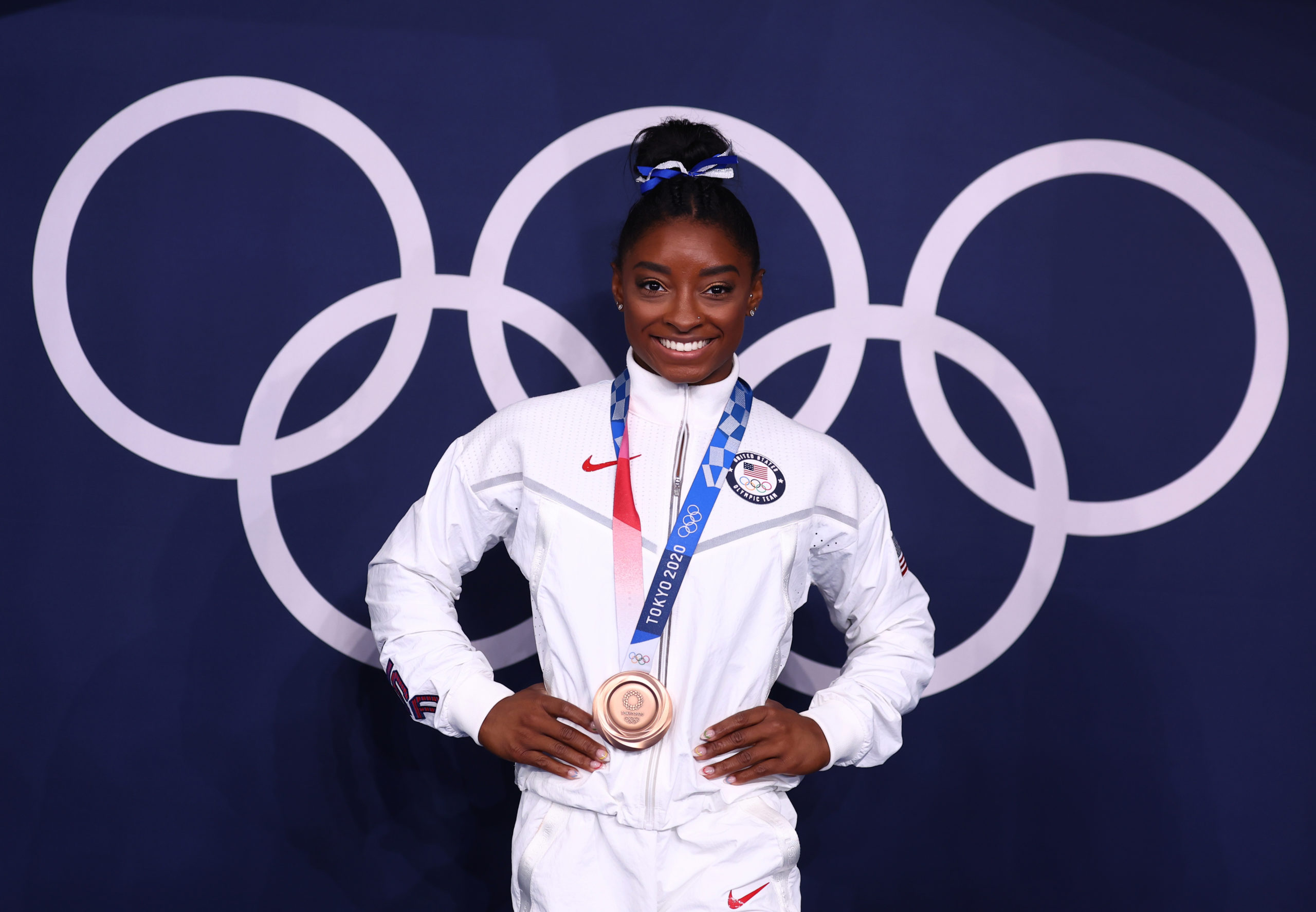Bronze medallist Simone Biles of the United States poses in front of the Olympic rings 