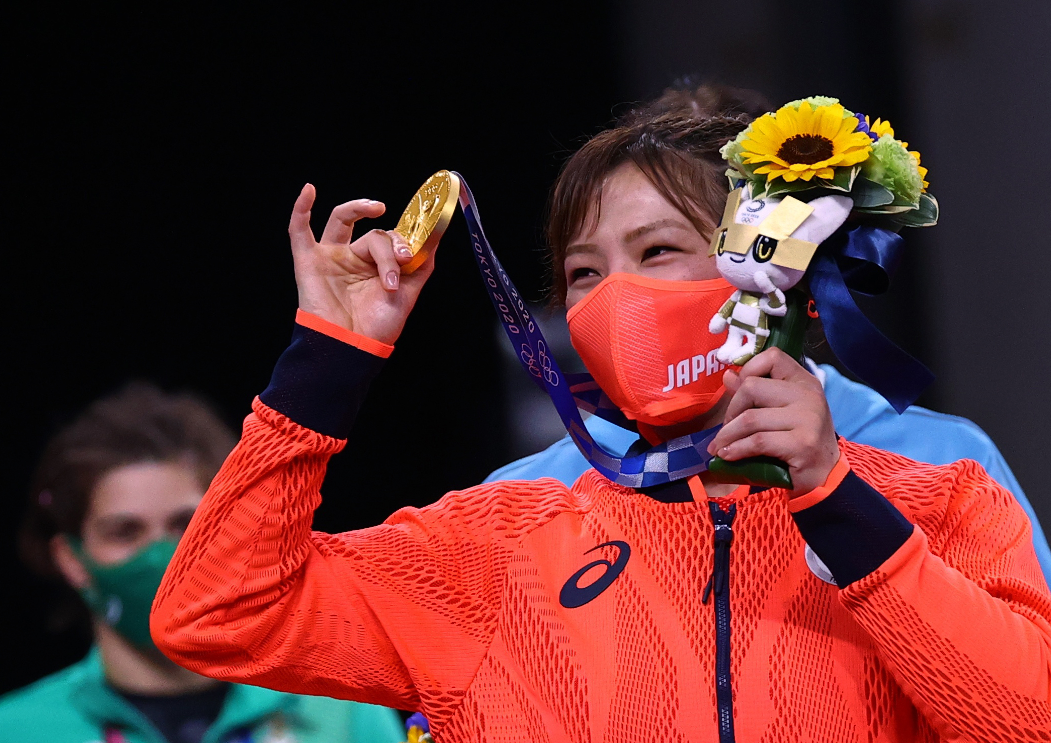 Gold medallist Yukako Kawai of Japan wearing a protective face mask poses with her medal 