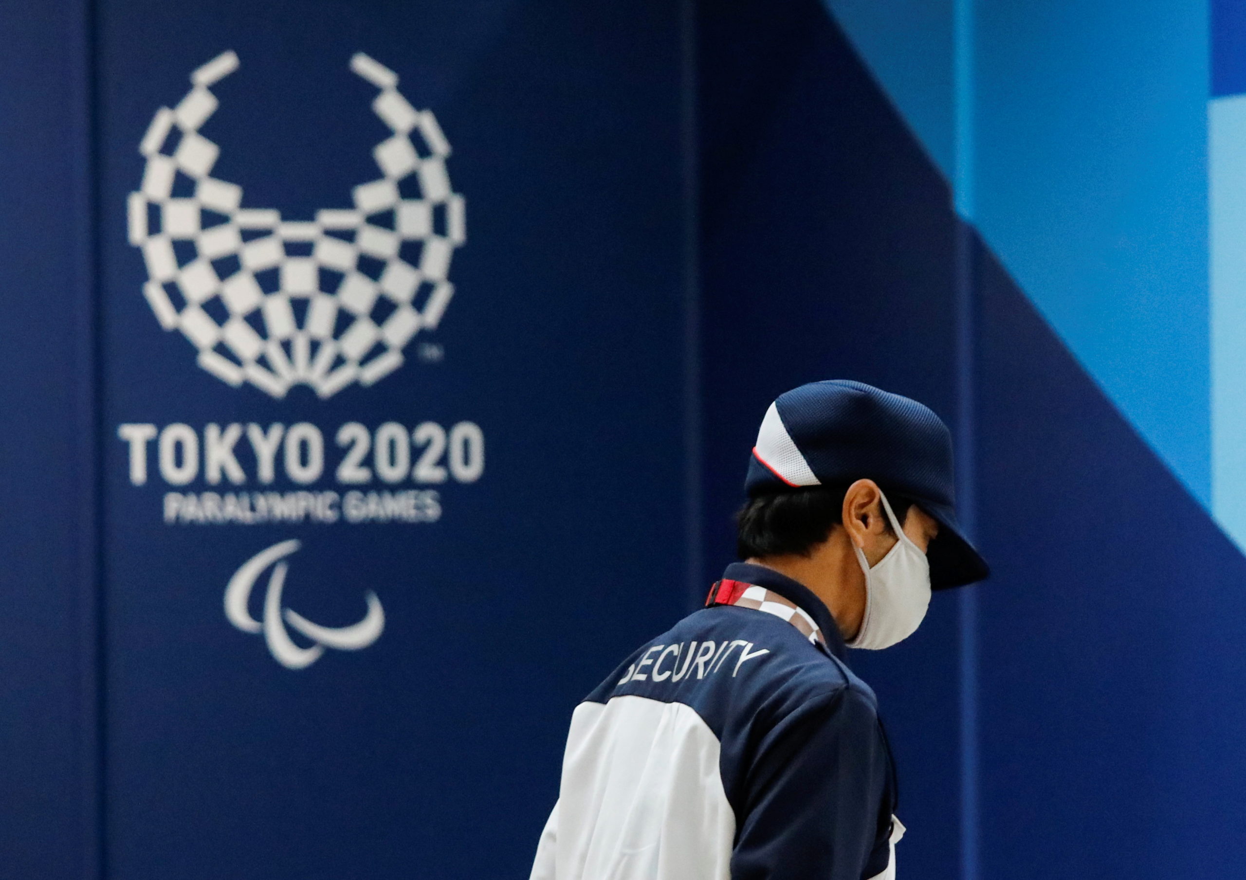 A security officer wearing a protective face mask walks past the logo of Tokyo 2020 Paralympic Games, amid the coronavirus disease (COVID-19) pandemic, in Tokyo, Japan, August 16, 2021.