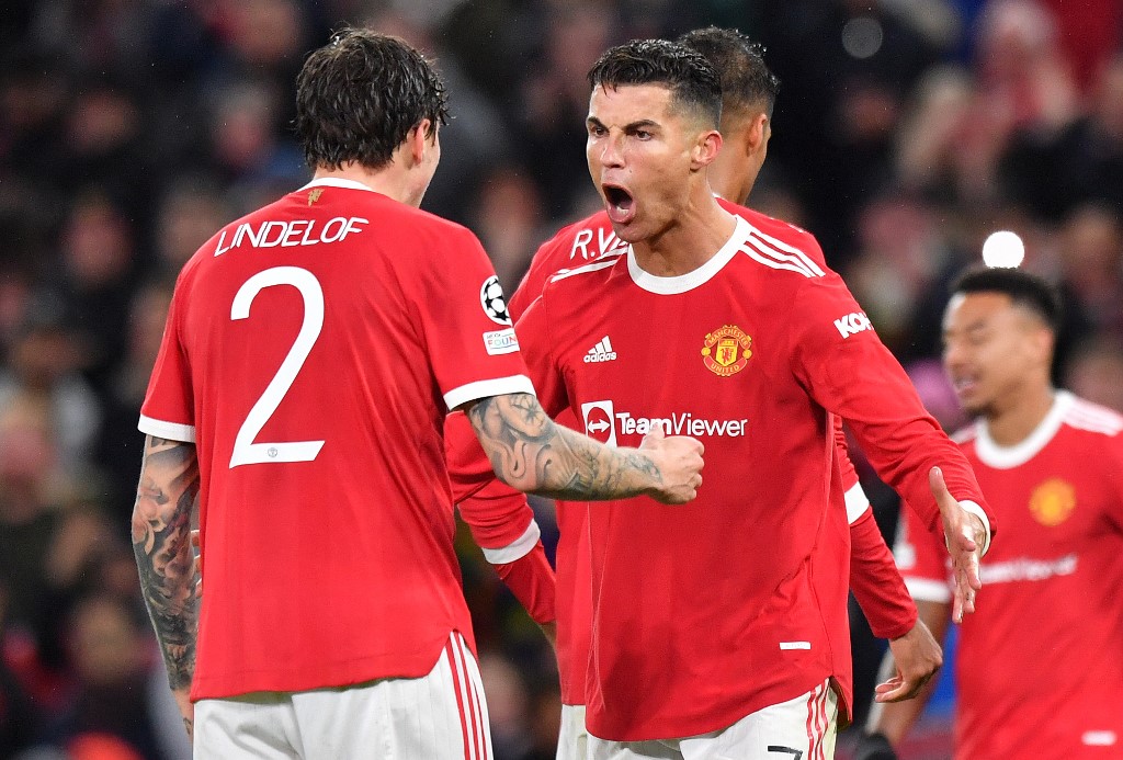 Manchester United's Portuguese striker Cristiano Ronaldo (C) celebrates with Manchester United's Swedish defender Victor Lindelof at the final whistle in the UEFA Champions League group F football  on September 29, 2021.