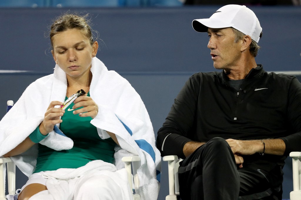 FILE–Simona Halep of Romania confers with her coach Darren Cahill between sets.