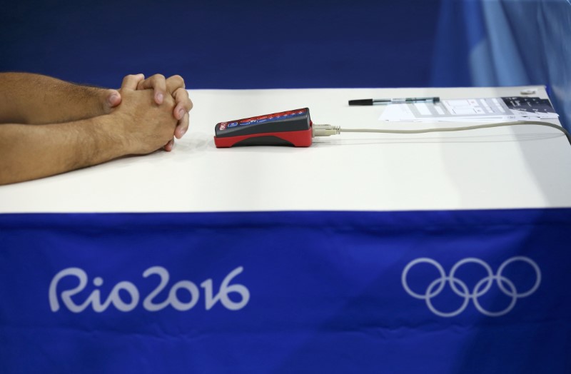 The hands of an official are seen during the bout in the Rio Olympics.