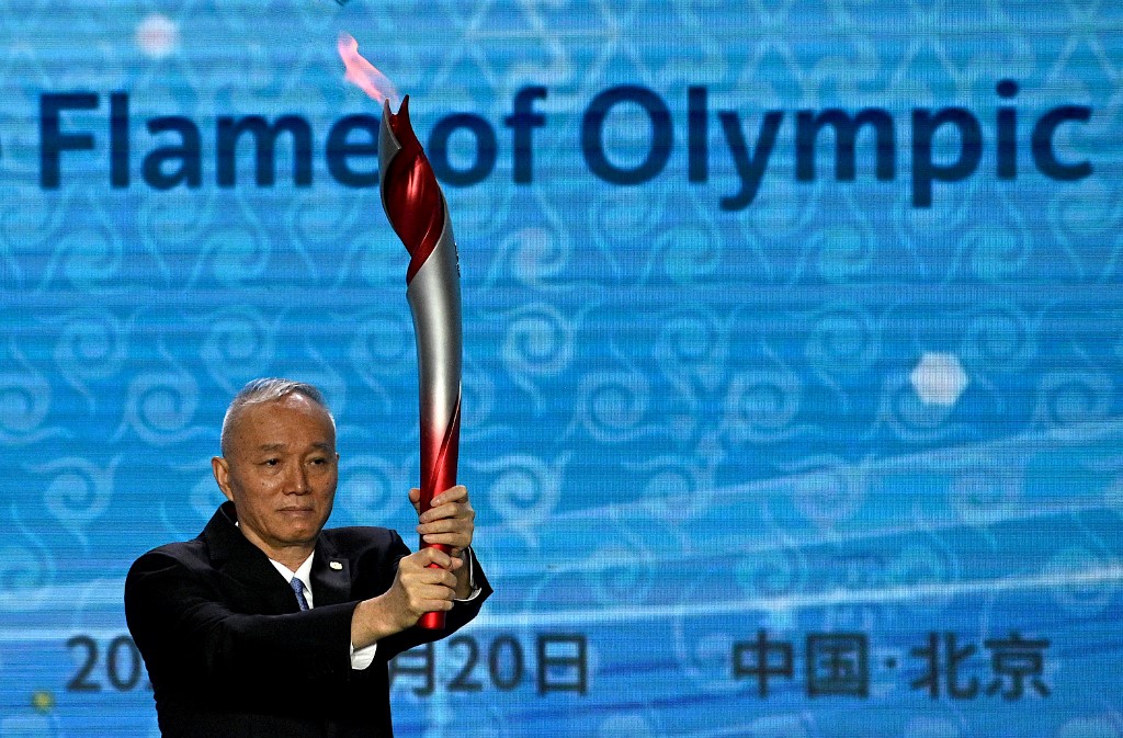 Communist Party Secretary of Beijing, Cai Qi, holds the torch before lighting the cauldron during the Olympic flame welcoming ceremony ahead of the Beijing 2022 Winter Olympics, in the lobby of the Olympic Tower in Beijing on October 20, 2021.