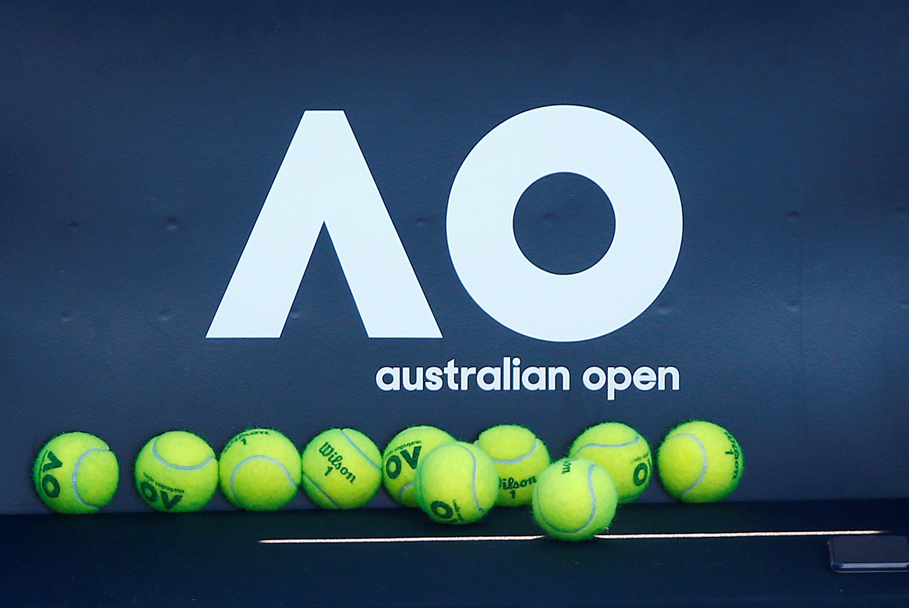 FILE PHOTO: Tennis - Australian Open - Melbourne, Australia, January 14, 2018. Tennis balls are pictured in front of the Australian Open logo before the tennis tournament. REUTERS/Thomas Peter
