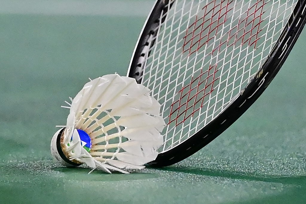China's He Bingjiao picks up the shuttlecock with her racket between points with Japan's Nozomi Okuhara in their women's singles badminton quarter final match during the Tokyo 2020 Olympic Games at the Musashino Forest Sports Plaza in Tokyo on July 30, 2021.