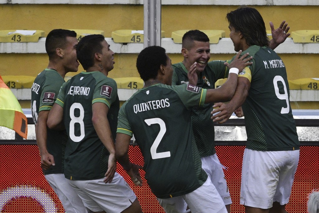 Players of Bolivia celebrate after scoring against Uruguay during their South American qualification football match for the FIFA World Cup Qatar 2022 at the Hernando Siles Olympic Stadium in La Paz on November 16, 2021. 