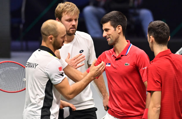 Germany's Kevin Krawietz (2ndL) and Tim Puetz (L) are congratulated by Serbia's Novak Djokovic (2ndR) and Nikola Cacic (R) at the end of the men's doubles group stage match between Serbia and Germany of the Davis Cup tennis tournament in Innsbruck, on November 27, 2021. (Photo by JOE KLAMAR / AFP)