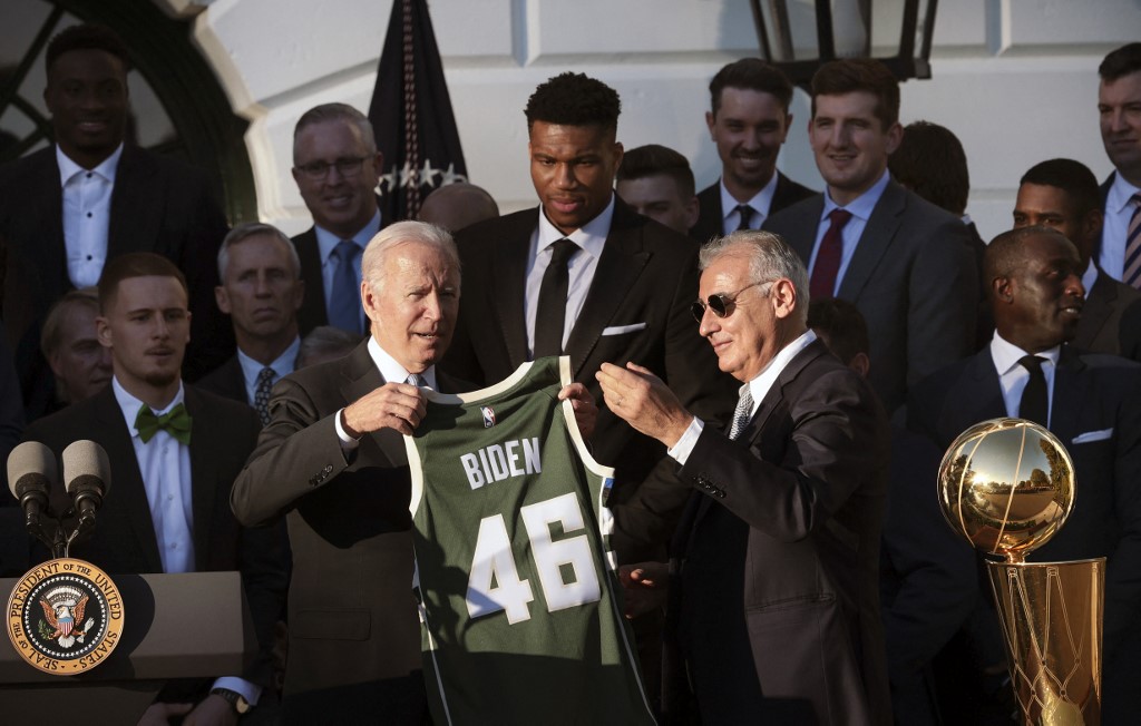 U.S. President Joe Biden (L) receive a jersey from Milwaukee Bucks owner Marc Lasry (R) as player Giannis Antetokounmpo (C) watches during an event where Biden honored the Bucks for winning the 2021 NBA Championship, on the South Lawn at the White House on November 08, 2021 in Washington, DC. 