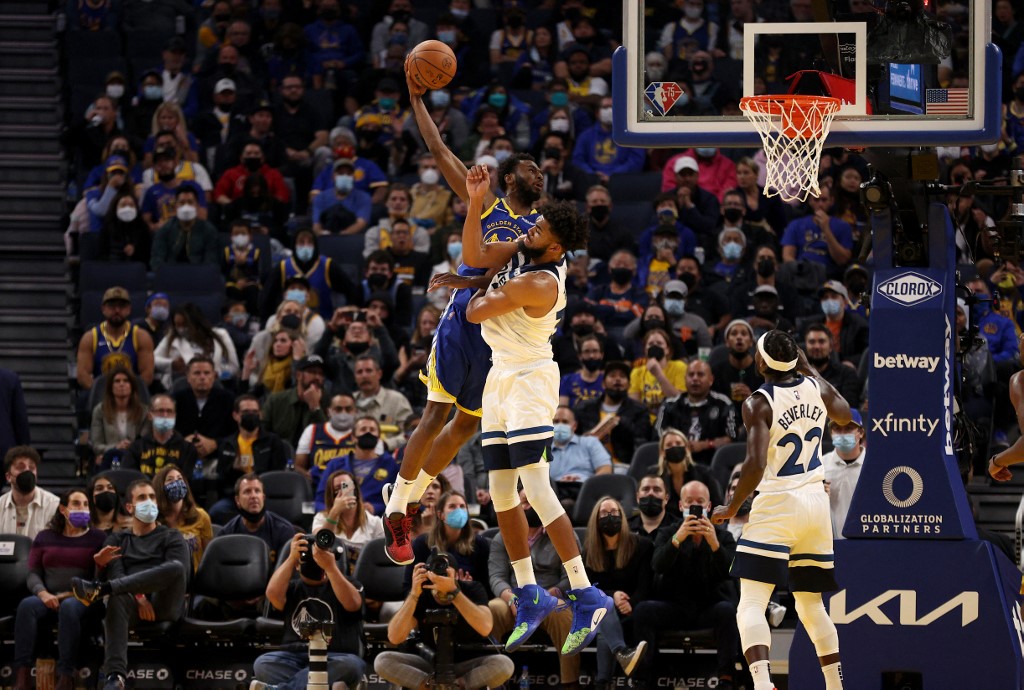 Andrew Wiggins #22 of the Golden State Warriors dunks the ball over Karl-Anthony Towns #32 of the Minnesota Timberwolves in the first half at Chase Center on November 10, 2021 in San Francisco, California. NOTE TO USER: User 