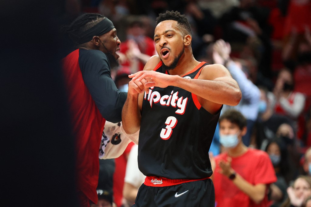 CJ McCollum #3 of the Portland Trail Blazers celebrates with Robert Covington #33 after making a three-point basket against the Toronto Raptors during the fourth quarter at Moda Center on November 15, 2021 in Portland, Oregon.