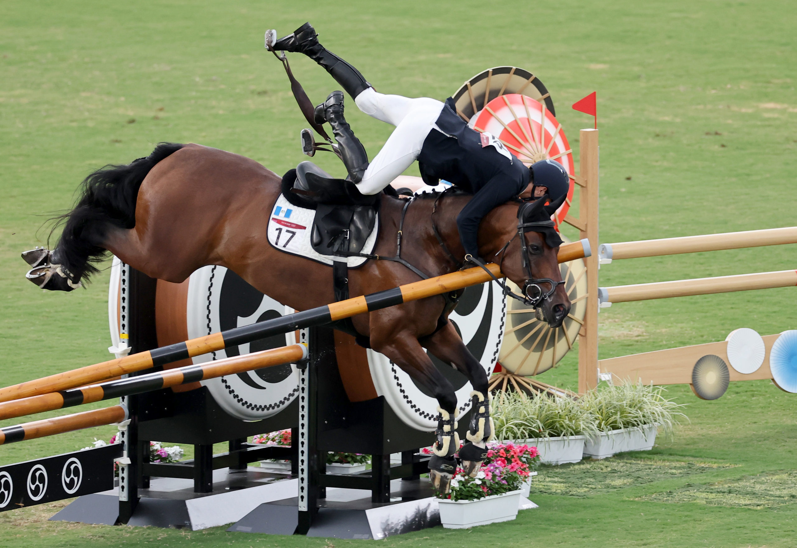 FILE–Charles Fernandez of Guatemala falls from his horse durin the modern pentathlon event in the Tokyo Olympics.