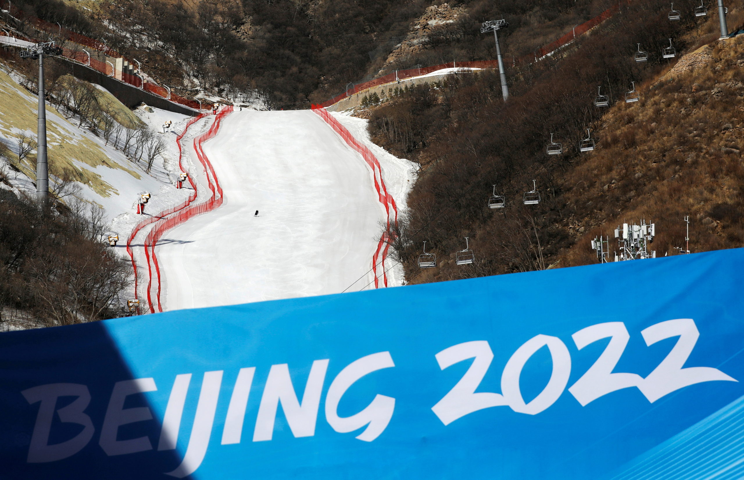 FILE PHOTO: A staff member skis down a slope during an organised media tour to the National Alpine Skiing Centre, a venue of the 2022 Winter Olympic Games, in Beijing's Yanqing district, China February 5, 2021. REUTERS/Tingshu Wang/File Photo