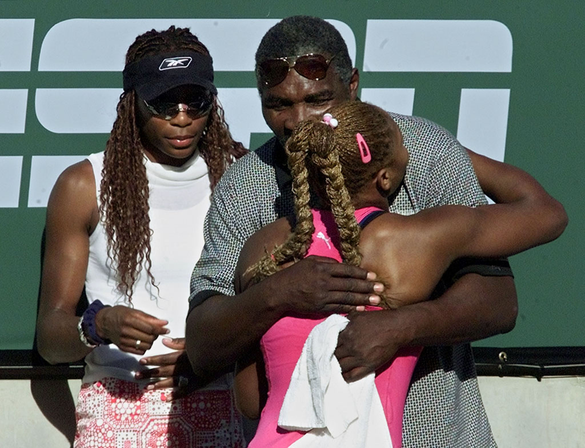 FILE PHOTO: Serena Williams of the United States (R) is hugged by her father Richard (top right) as sister Venus Williams waits her turn following Serena's 4-6 6-4 6-2 victory [over Kim Clijsters of Belgium] in the women's final match March 17, 2001 at the Tennis Masters Series in Indian Wells, California . All three Williams' were 