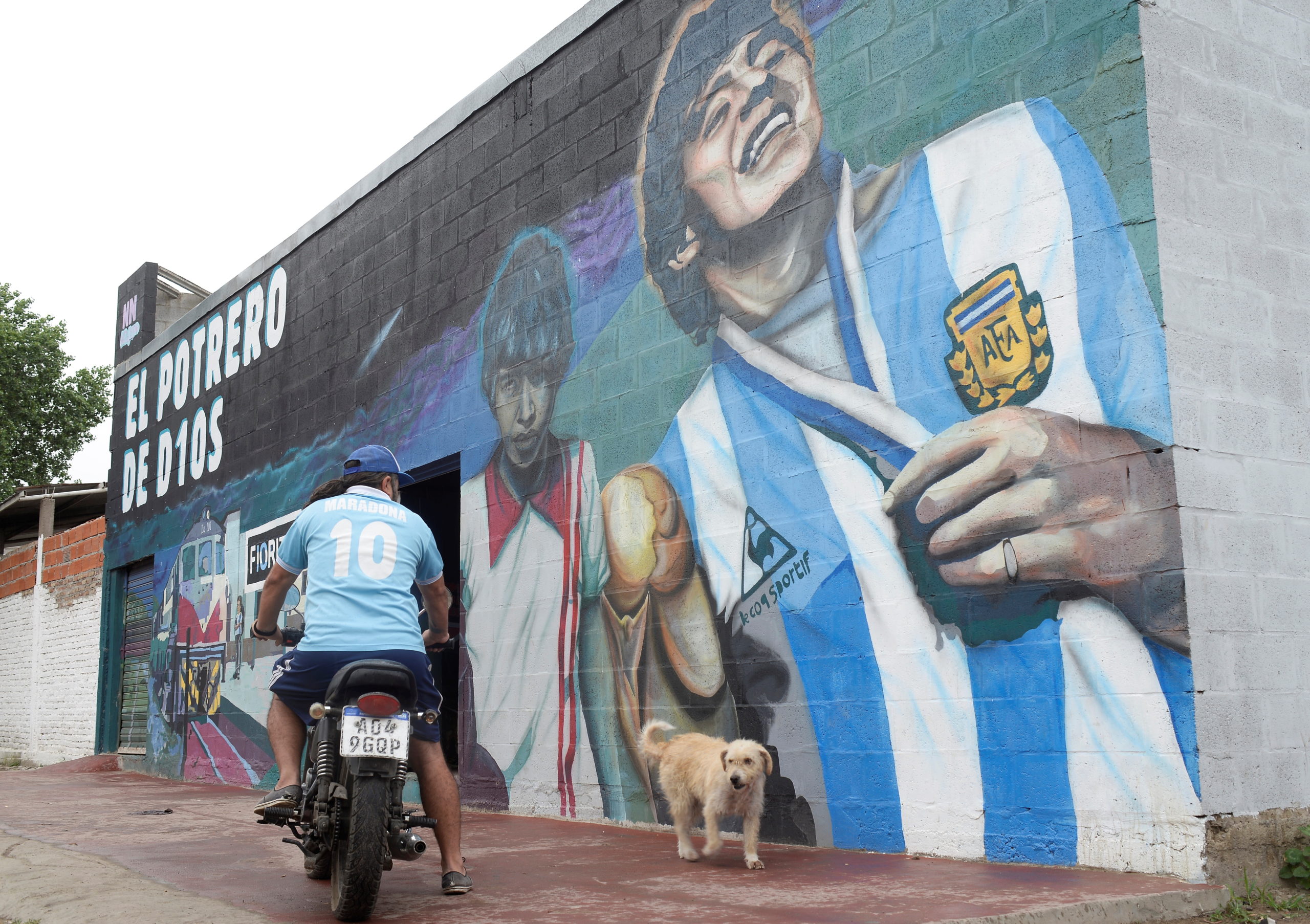 A man rides his motorbike next to a mural depicting late soccer legend Diego Armando Maradona, on his first death anniversary, in Villa Fiorito, on the outskirts of Buenos Aires, Argentina November 25, 2021. 