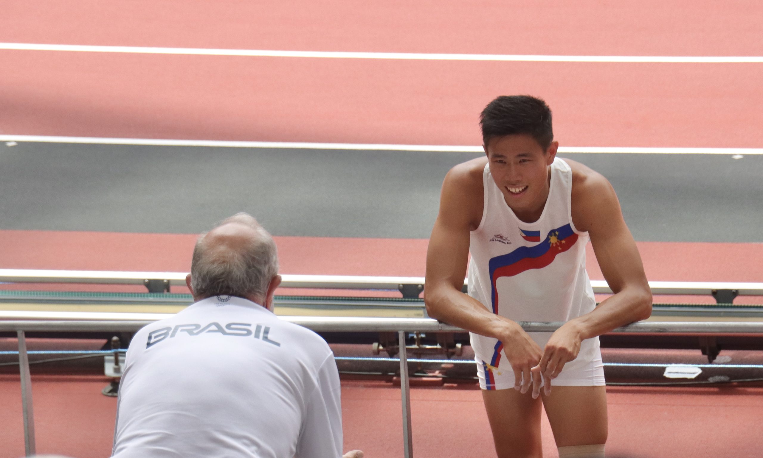EJ Obiena (right) and Vitaly Petrov discuss strategy during a break in competition in the qualifying round of the Tokyo Olympics pole vault competition.