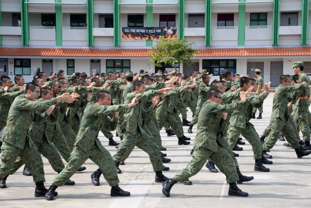 (FILES) In this file photo taken on February 7, 2017 National Service recruits demonstrate hand-to-hand combat moves as part of their two-month basic training on Pulau Tekong off Singapore. - Singaporean men are required to spend two years in the military, police or emergency services upon turning 18, but critics have increasingly questioned this obligation when it comes to promising young athletes, saying it can torpedo sporting careers just as they are getting off the ground. 