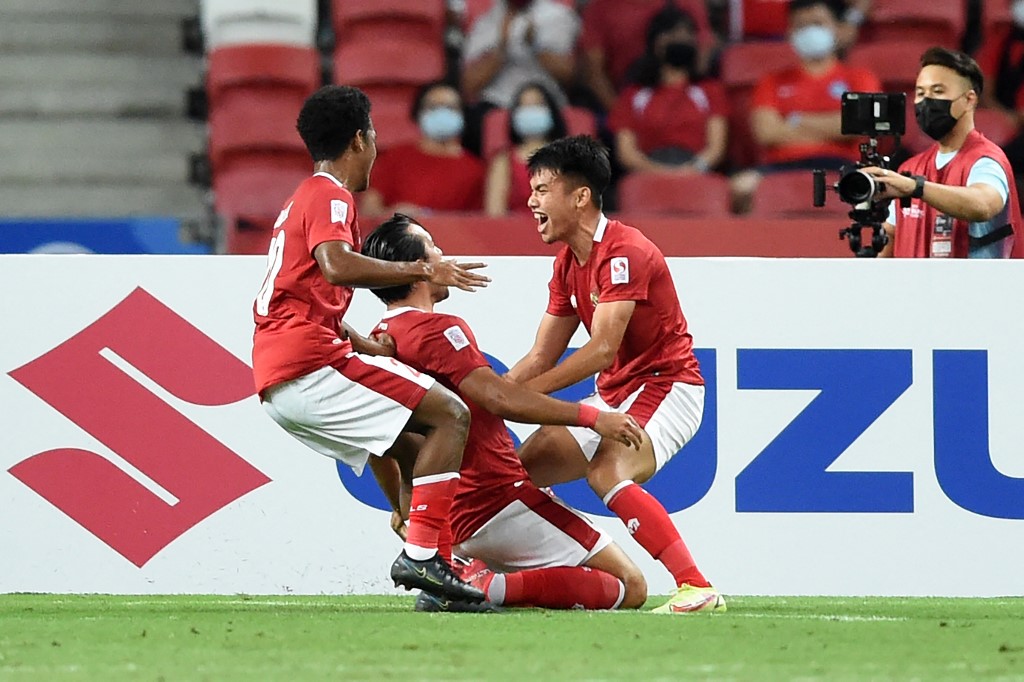 Indonesia's Ezra Harm Ruud Walian (C) is congratulated by teammates after scoring during the second leg of the AFF Suzuki Cup 2020 football semi-final match between Singapore and Indonesia at the National Stadium in Singapore on December 25, 2021. 