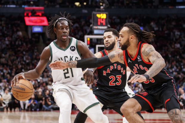 Gary Trent Jr. #33 and Fred VanVleet #23 of the Toronto Raptors reach in as Jrue Holiday #21 of the Milwaukee Bucks dribbles up court during the second half of their NBA game at Scotiabank Arena on December 2, 2021 in Toronto, Canada. NOTE TO USER: User expressly acknowledges and agrees that, by downloading and or using this Photograph, user is consenting to the terms and conditions of the Getty Images License Agreement. Cole Burston/Getty Images/AFP (Photo by Cole Burston / GETTY IMAGES NORTH AMERICA / Getty Images via AFP)