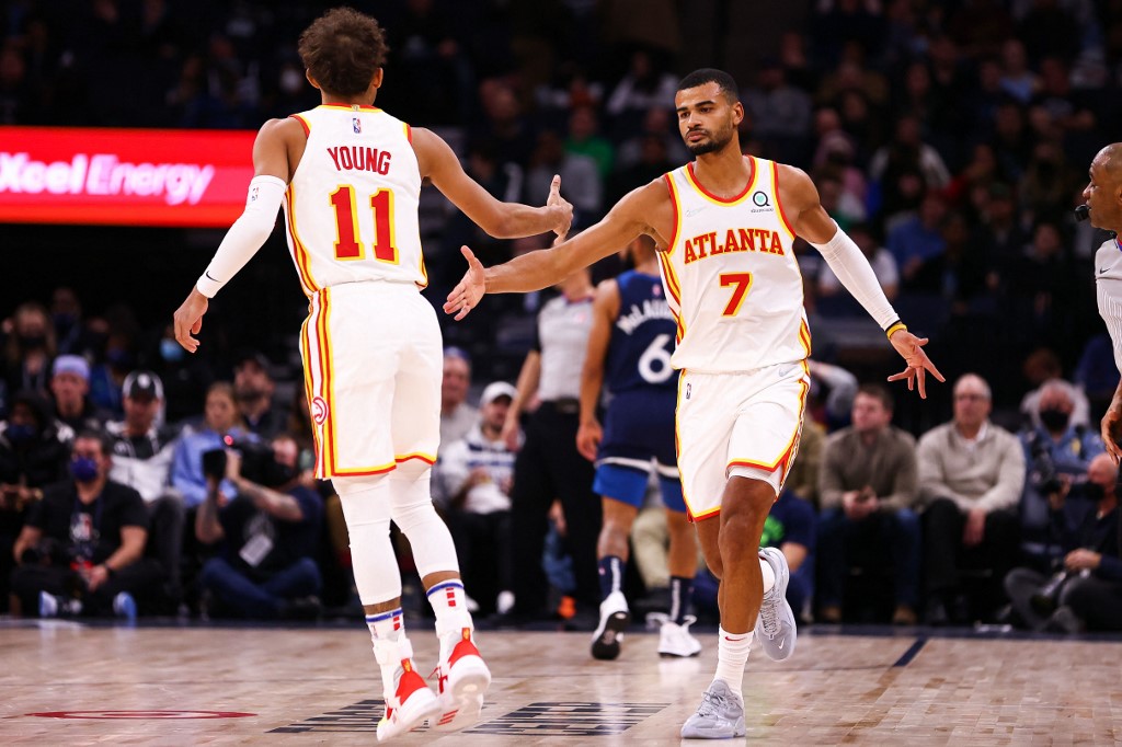 Timothe Luwawu-Cabarrot #7 and Trae Young #11 of the Atlanta Hawks celebrate after scoring during the fourth quarter against the Minnesota Timberwolves at Target Center on December 6, 2021 in Minneapolis, Minnesota. 