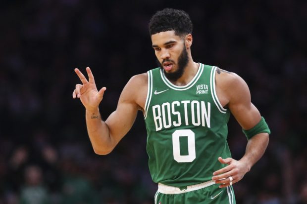 ayson Tatum #0 of the Boston Celtics reacts after hitting a three-point shot during a game against the Milwaukee Bucks at TD Garden on December 13, 2021 in Boston, Massachusetts.