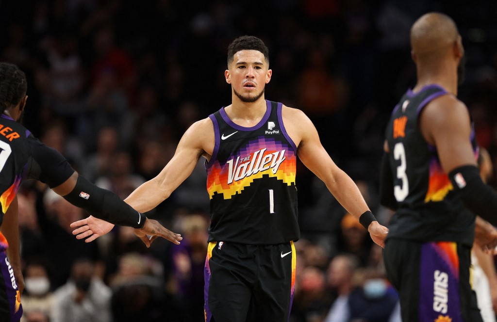 Devin Booker #1 of the Phoenix Suns high fives teammates after scoring against the Golden State Warriors during the first half of the NBA game at Footprint Center on November 30, 2021 in Phoenix, Arizona.