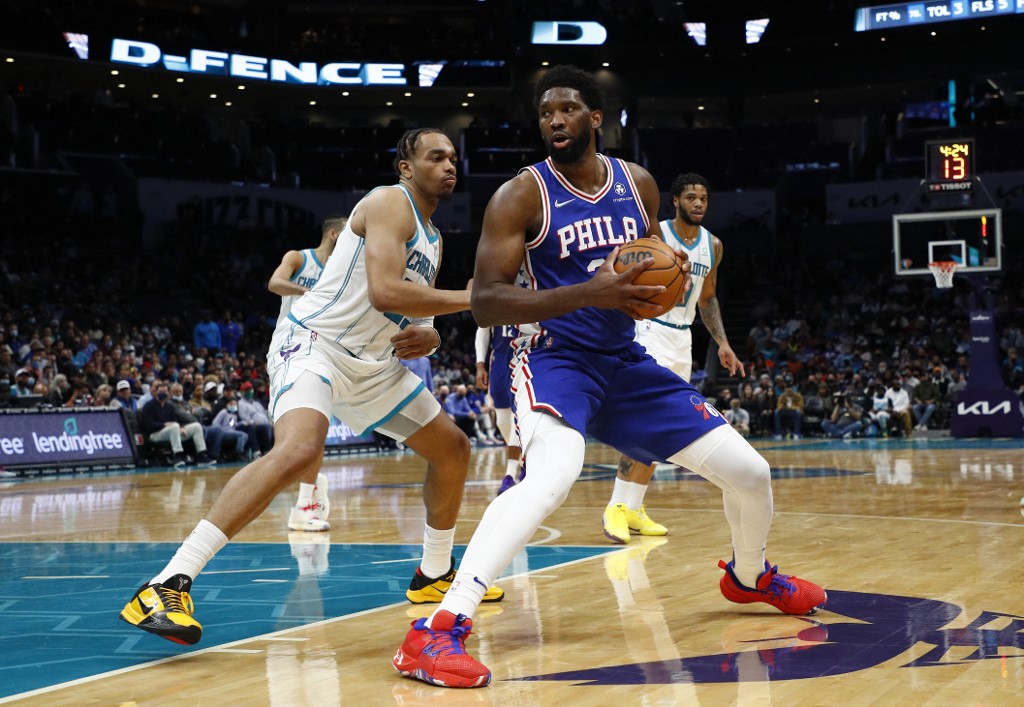 Joel Embiid #21 of the Philadelphia 76ers posts up against P.J. Washington #25 of the Charlotte Hornets during the second half of the game at Spectrum Center on December 06, 2021 in Charlotte, North Carolina.