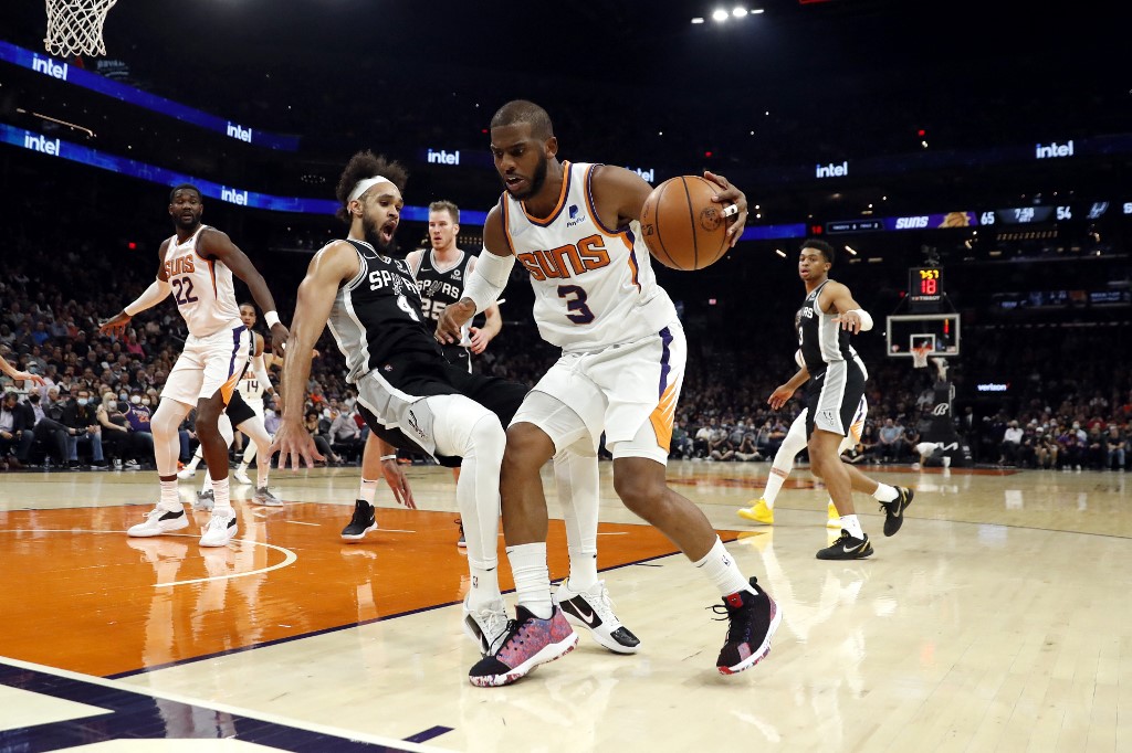 Chris Paul #3 of the Phoenix Suns fouls Derrick White #4 of the San Antonio Spurs during the third quarter at Footprint Center on December 06, 2021 in Phoenix, Arizona.