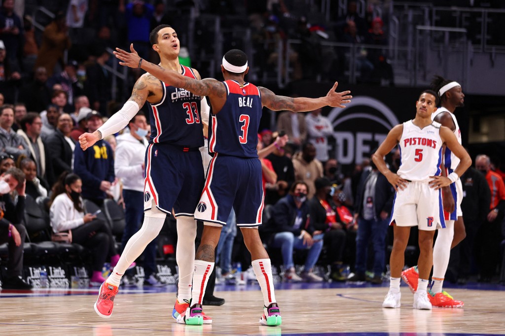 Kyle Kuzma #33 of the Washington Wizards celebrates a three point basket with Bradley Beal #3 to take the lead with .06 seconds left in overtime against the Detroit Pistons at Little Caesars Arena on December 08, 2021 in Detroit, Michigan