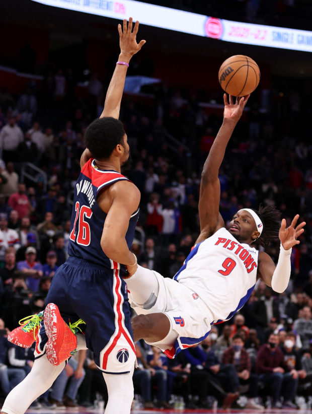 Jerami Grant #9 of the Detroit Pistons tries to get a second half shot off over Spencer Dinwiddie #26 of the Washington Wizards at Little Caesars Arena on December 08, 2021 in Detroit, Mich