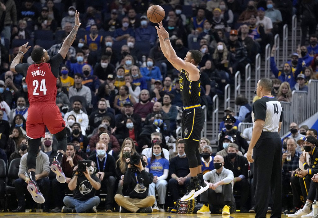  Stephen Curry #30 of the Golden State Warriors shoots a three-point shot against Norman Powell #24 of the Portland Trail Blazers during the first quarter of an NBA basketball game at Chase Center on December 08, 2021 in San Francisco, California. 