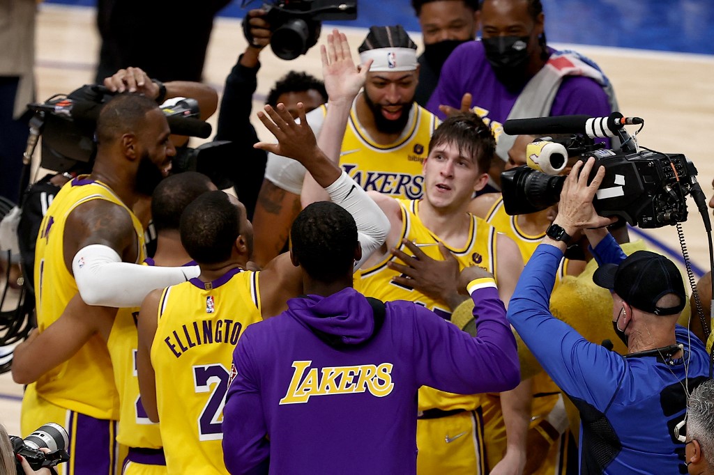 Austin Reaves #15 of the Los Angeles Lakers reacts after shooting the game-winning shot against Tim Hardaway Jr. #11 of the Dallas Mavericks in overtime at American Airlines Center on December 15, 2021 in Dallas, Texas.   
