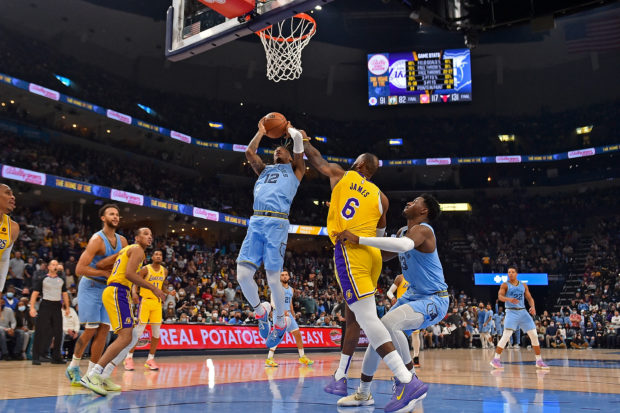 Memphis Grizzlies guard Ja Morant #12 goes to the basket against Los Angeles Lakers forward LeBron James #6 during the second half at FedExForum on December 29, 2021 in Memphis, Tennessee. NOTE TO USER: User expressly acknowledges and agrees that, by downloading and or using this photograph, User is consenting to the terms and conditions of the Getty Images License Agreement. Justin Ford/Getty Images/AFP (Photo by Justin Ford / GETTY IMAGES NORTH AMERICA / Getty Images via AFP)