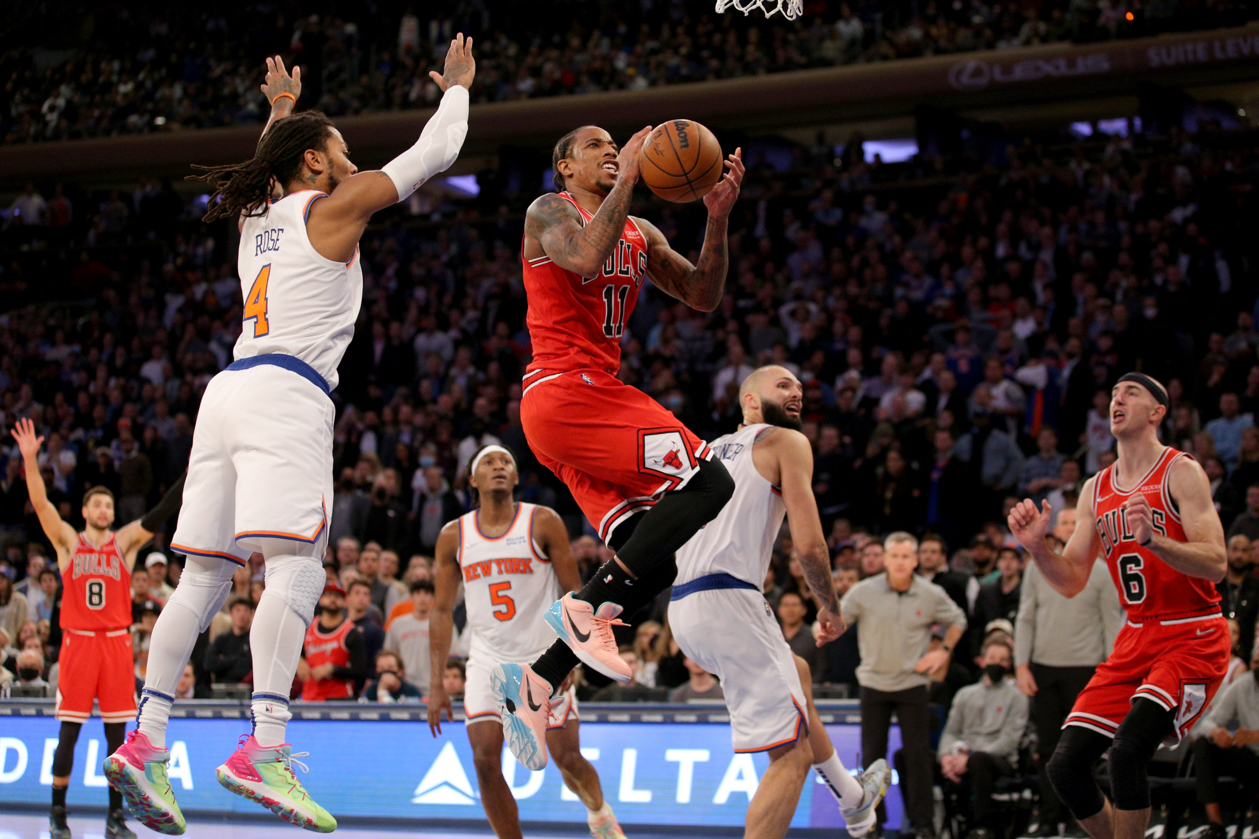 Chicago Bulls forward DeMar DeRozan (11) drives to the basket against New York Knicks guard Derrick Rose (4) and guard Evan Fournier (13) during the fourth quarter at Madison Square Garden. 