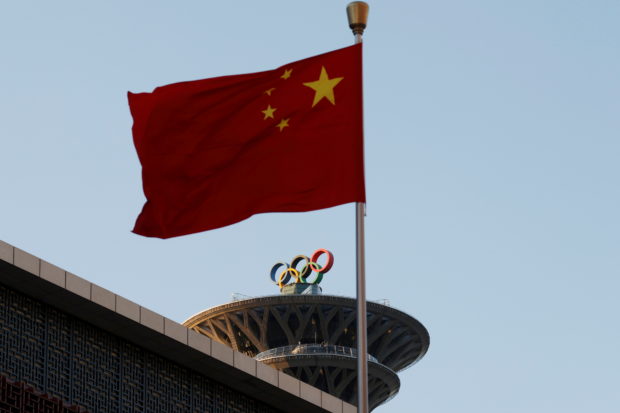 FILE PHOTO: A Chinese flag flutters near the Olympic rings on the Olympic Tower in Beijing, China November 11, 2021. REUTERS/Carlos Garcia Rawlins