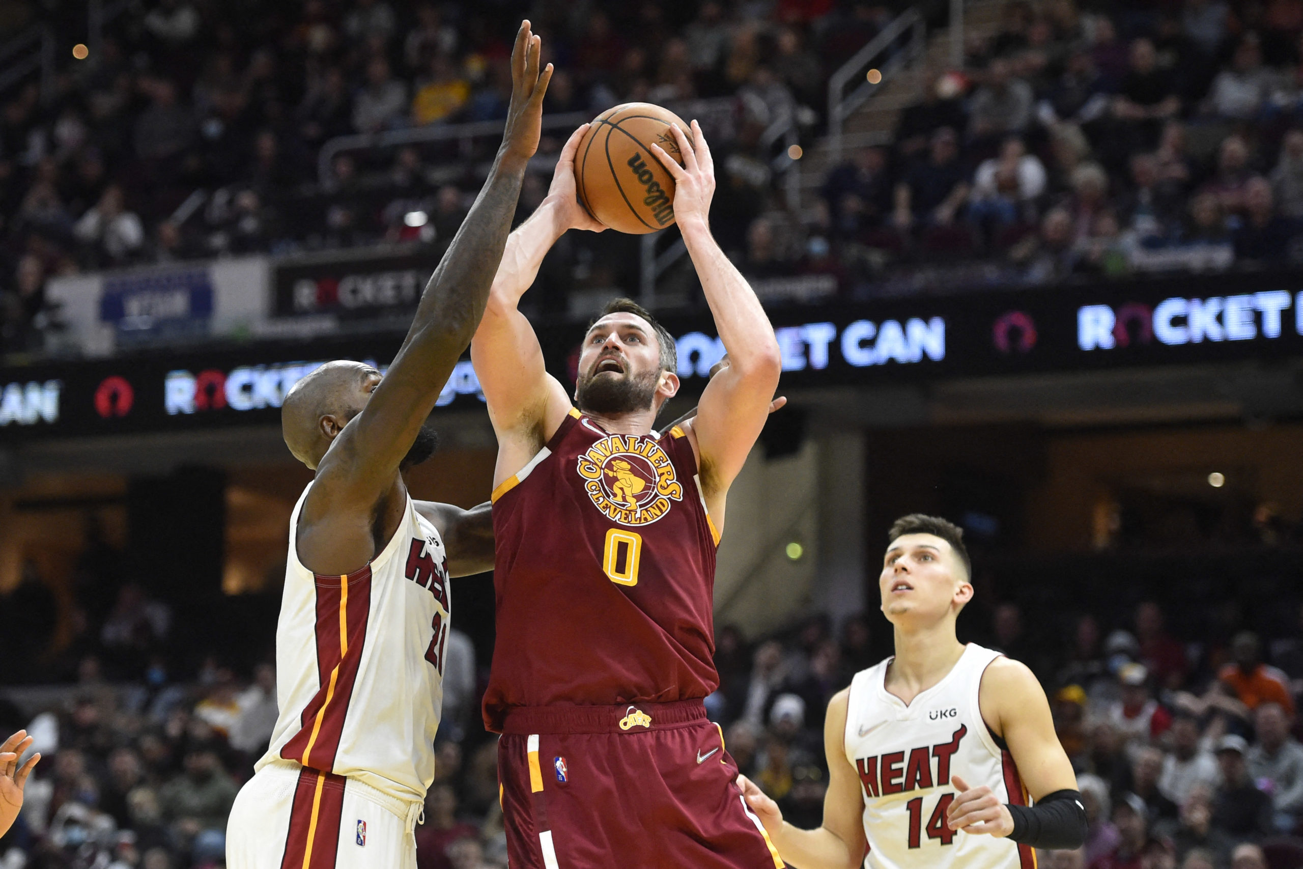Cleveland Cavaliers forward Kevin Love (0) shoots between Miami Heat center Dewayne Dedmon (21) and guard Tyler Herro (14) in the fourth quarter at Rocket Mortgage FieldHouse. 